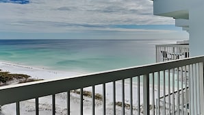 Uma varanda com vista para a praia e o oceano.