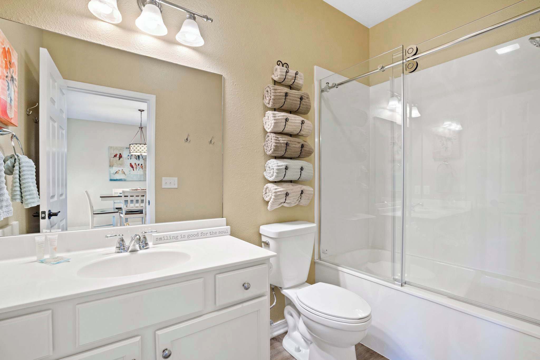 Un baño con lavamanos blanco, inodoro y cabina de ducha de vidrio.