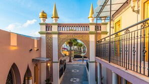 An ornate archway with a cobblestone path leading through it. - Vila Origens Boutique Hotel Albufeira (Albufeira)