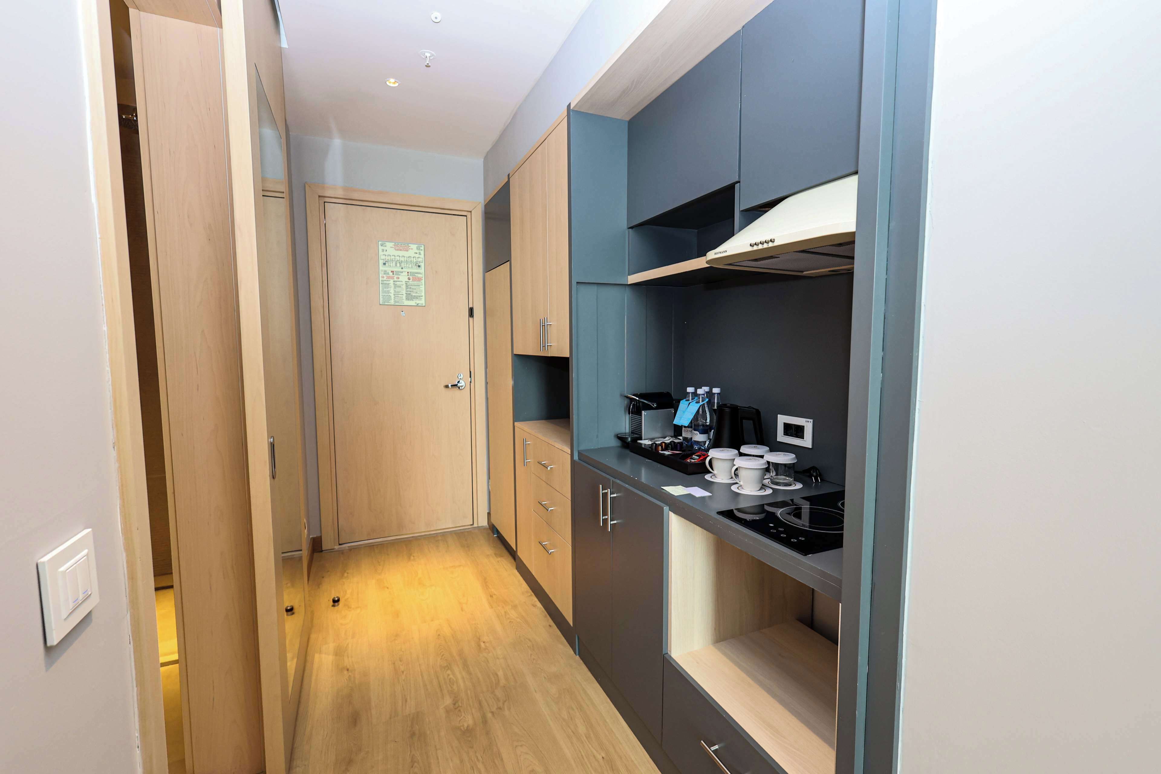 A narrow kitchen with a built-in stove, cabinets, and a microwave.