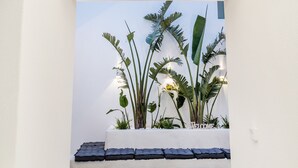 A narrow hallway with white walls and wooden beams, leading to a balcony with potted plants and a 'Welcome' sign. - Alenor City Hotel (Naxos)