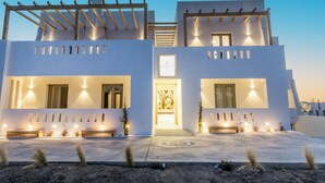 A modern two-story building with a symmetrical facade, large windows, and a central entrance. - Alenor City Hotel (Naxos)