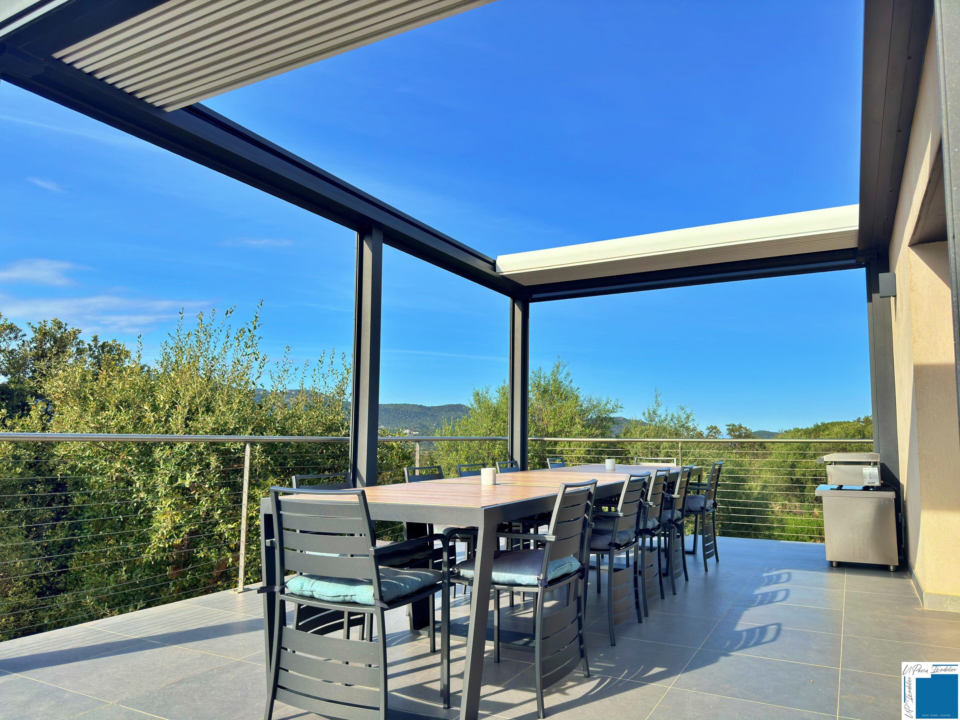 Un espace extérieur aménagé pour prendre les repas, avec vue sur la campagne.