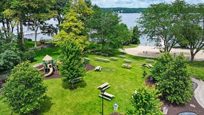 Un parc équipé de tables de pique-nique, d’une aire de jeux et d’une zone aménagée en plage.
