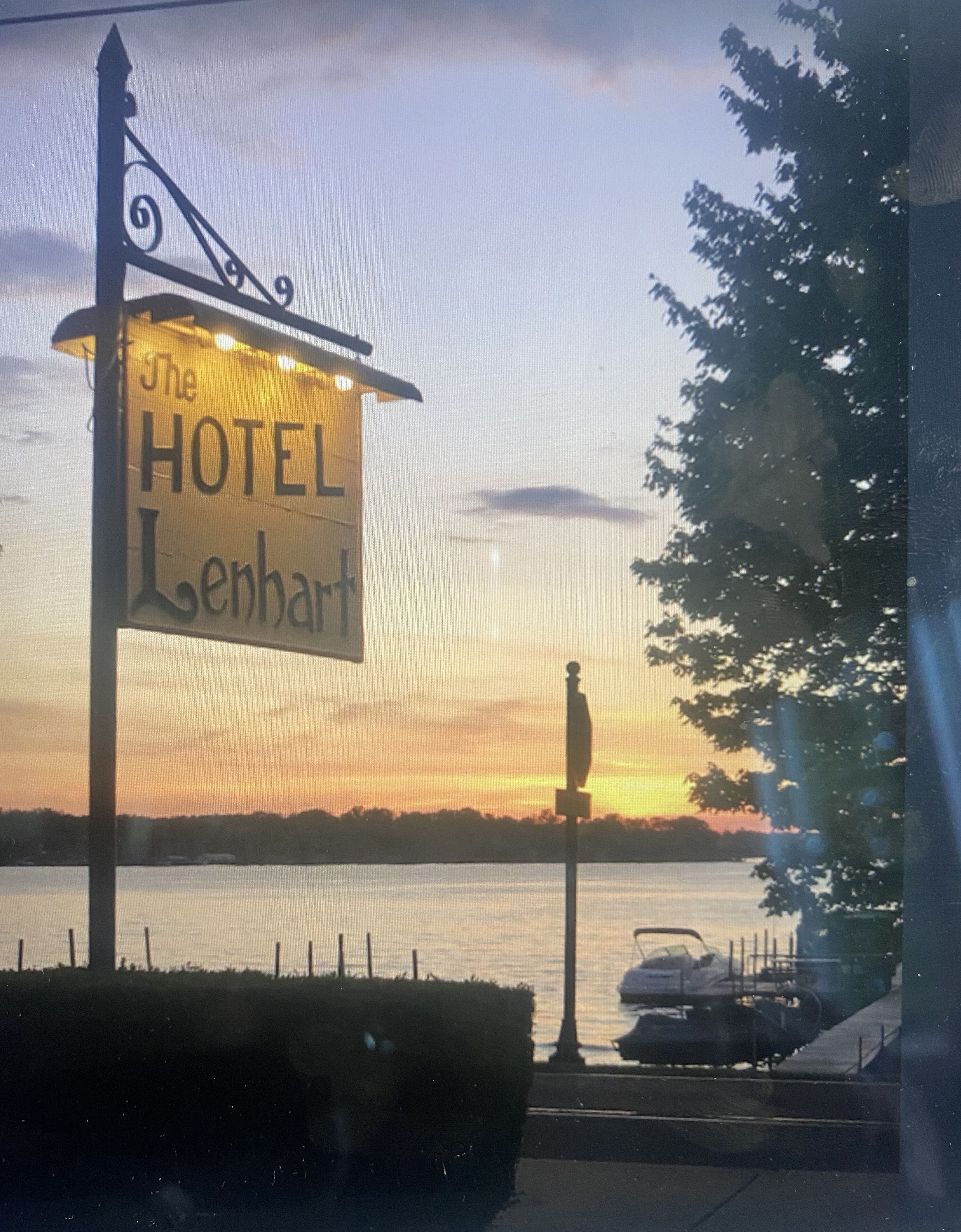 Ein Hotelschild mit dem Schriftzug "The Hotel Lenhart" vor einem Sonnenuntergang.