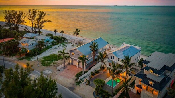 Zona residencial costera con casas, una carretera y una playa.