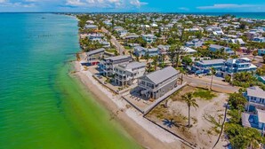 Zona residencial costera con casas, una playa y agua azul cristalina.