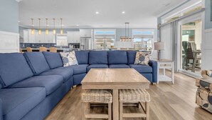 Un soggiorno moderno con un divano componibile blu, un tavolino in legno e cesti di vimini.