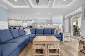 Uma sala de estar moderna com um sofá em forma de L azul, uma mesa de centro de madeira e cestos de vime.