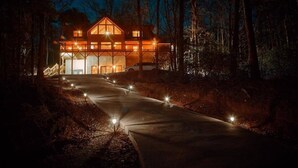 A modern two-story house with a large garage, surrounded by a forested area. - Gated Community, Hot Tub, Game Room (Lake Lure)