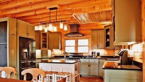 A spacious kitchen with wooden cabinets, a central island, and modern appliances. - Gated Community, Hot Tub, Game Room (Lake Lure)