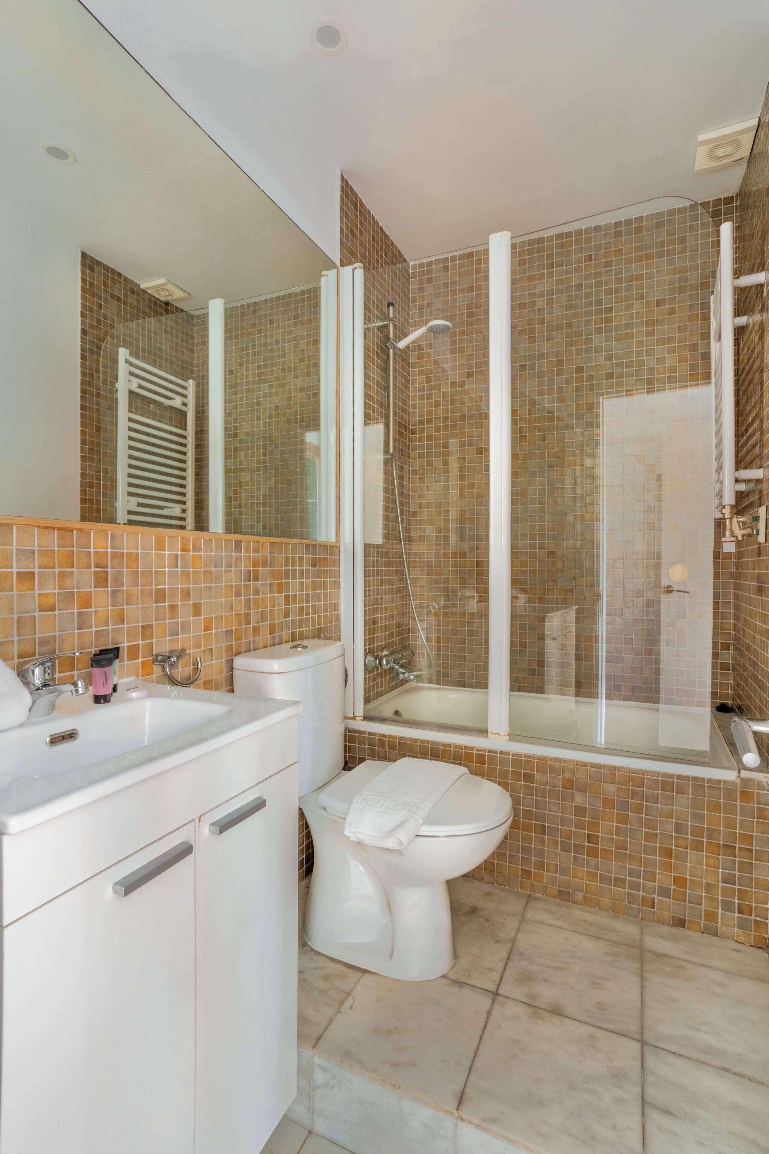Een badkamer met een witte wastafel, toilet en douche.