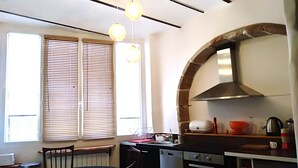 Une cuisine moderne dotée d’un îlot central, d’un four encastré et d’un coin repas avec une table et des chaises.