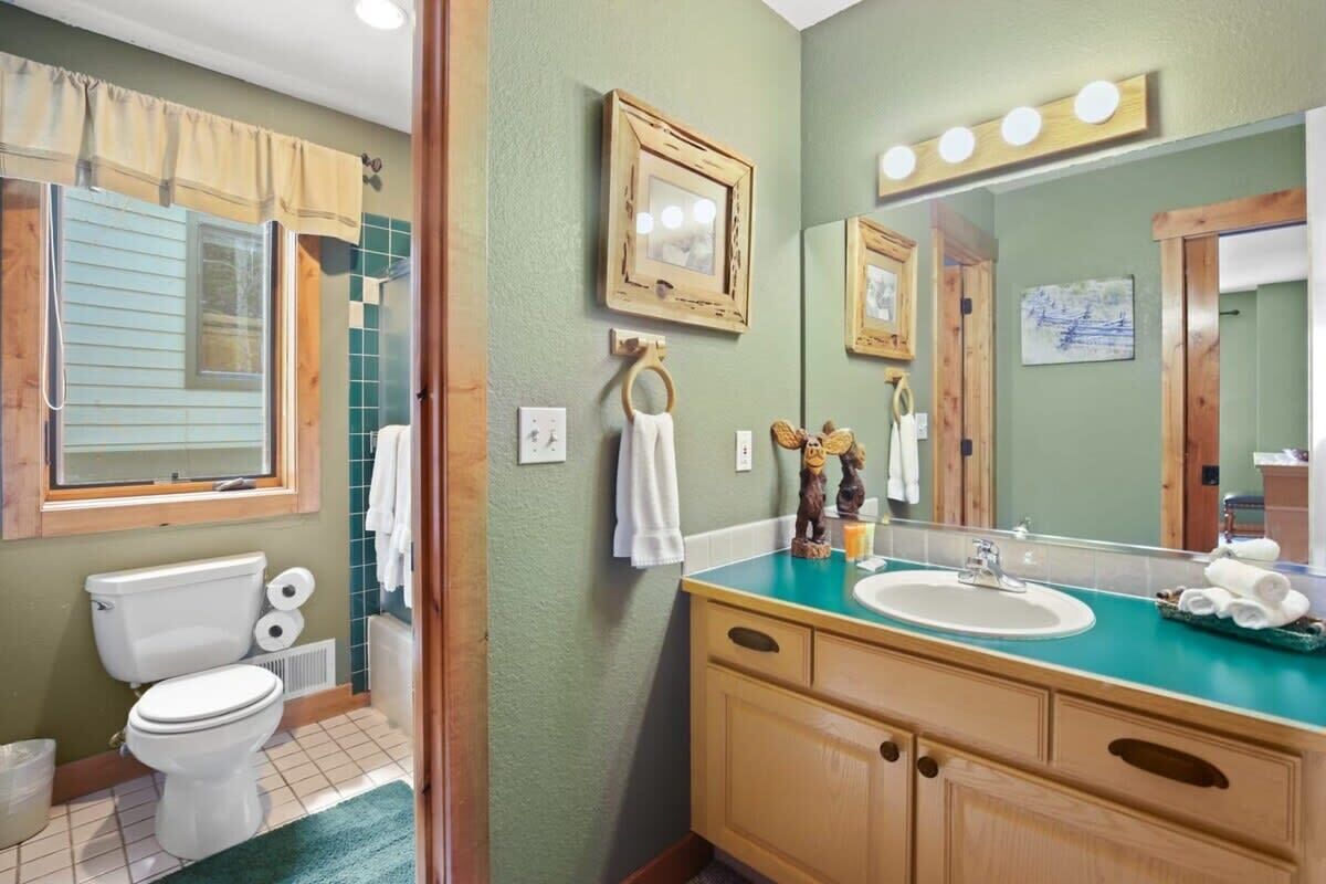 Un baño con inodoro, lavamanos y espejo.