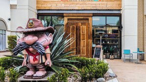 A restaurant named "El Jefe Tequilas" with a wooden facade and a large statue of a character holding a plant.