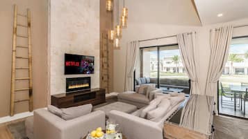 Townhouse, flere senger, terrasse, hageutsikt (Villa at Magic Village) | Oppholdsområde | En 40-tommers TV med kabel-kanaler samt peis