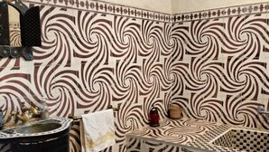A bathroom with a patterned tile wall, a sink, and a towel rack. - JNANE GHMATE (marrakech)