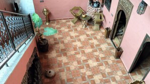 A courtyard with a checkered floor, a small fountain, and a seating area with chairs and a table. - JNANE GHMATE (marrakech)
