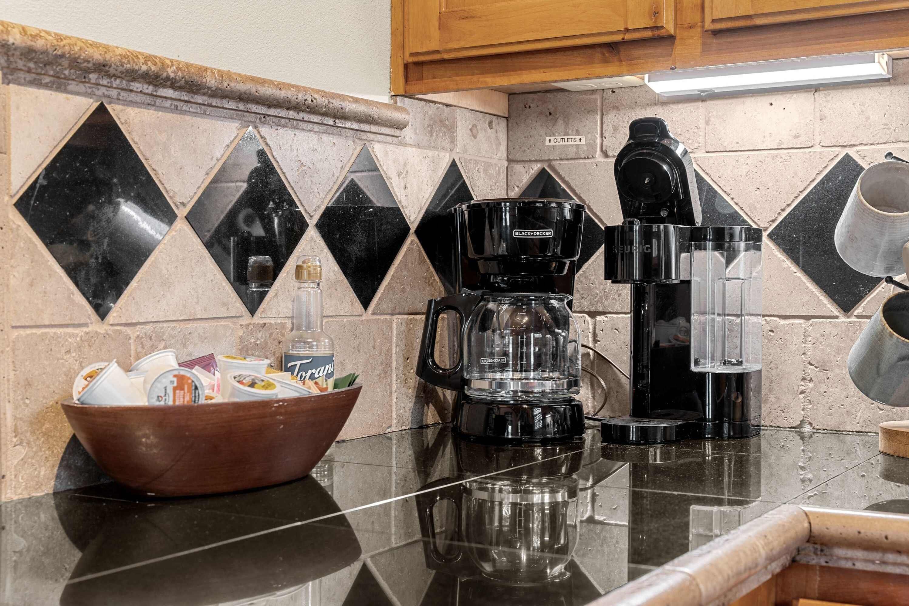 A kitchen with a coffee maker, a bowl of food, and a tiled backsplash.
