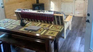 Ein gemütliches Blockhaus-Interieur mit Holztisch, Bank und Kamin.