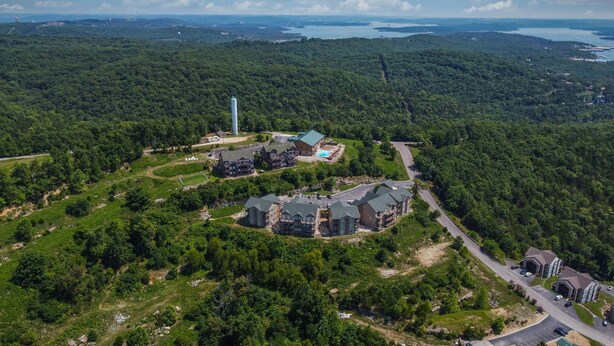 Luftaufnahme eines Resorts mit mehreren Gebäuden, einem Schwimmbad und einem großen Wasserturm.