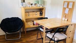 Une pièce comprenant un bureau en bois, une chaise, un miroir et une étagère sur laquelle sont disposés divers objets.