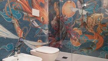 A bathroom with a large, colorful mural of sea creatures on the wall, a white sink, and a toilet.