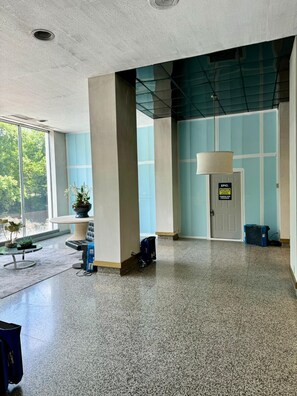 Guests enter a spacious lobby with high ceilings and large windows, surrounded by clean, well-maintained spaces.