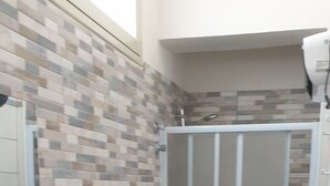 A bathroom with a tiled backsplash, a sink, a toilet, and a shower enclosure. - Il Canneto Vecchia Marina (castelvetrano)