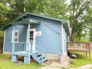 A small, single-story cabin with a porch and a staircase leading to the entrance.