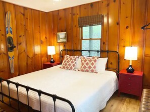 Cozy retreat with a large bed, bedside tables, and a window offering a view of the outdoors.