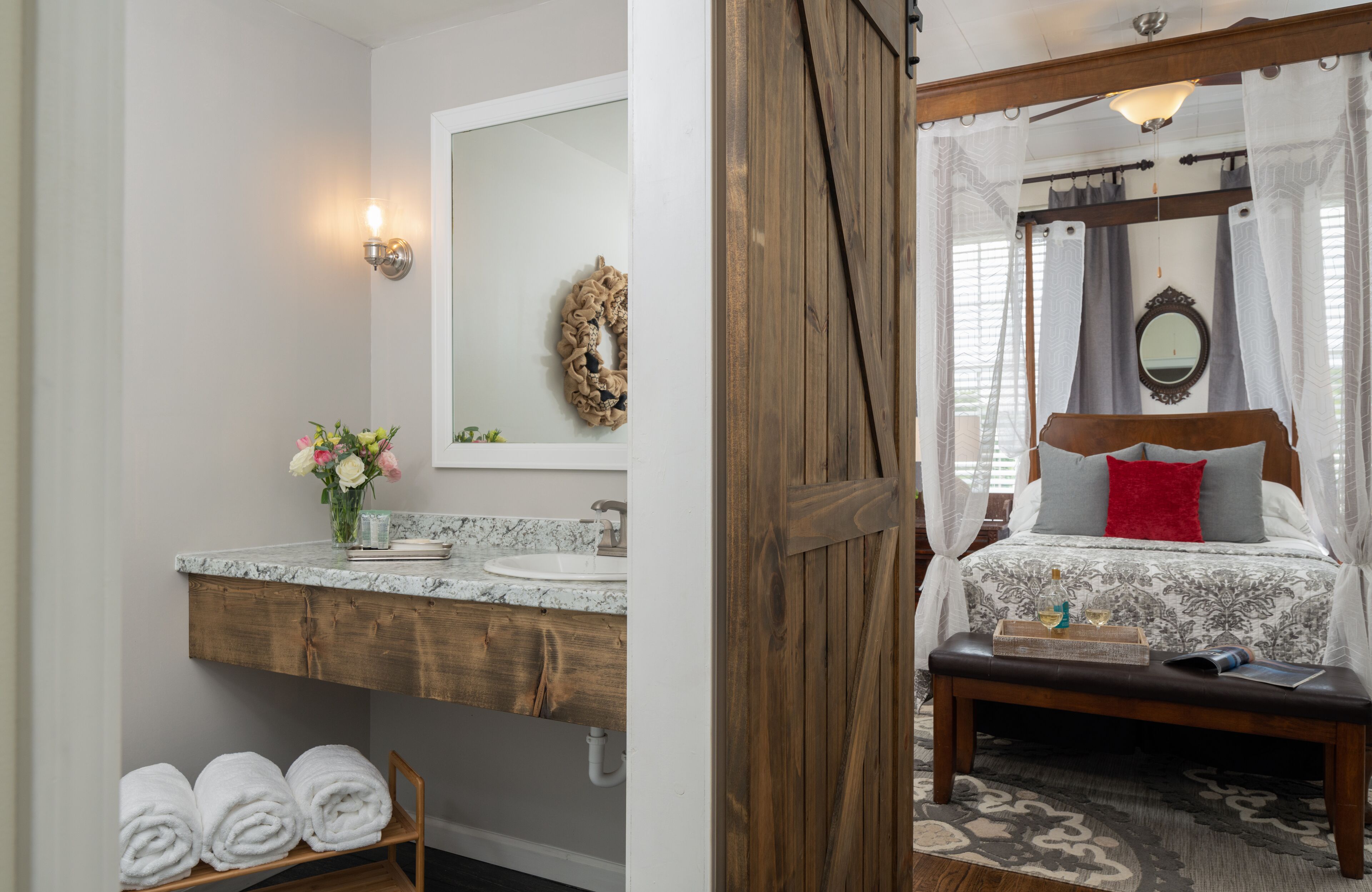 Un baño con tocador de madera, espejo y barra para toallas.