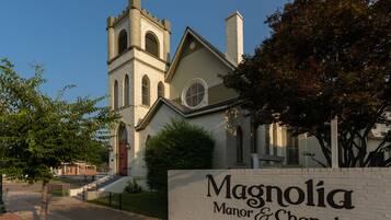 A church with a prominent tower and a sign reading "Magnolia Manor & Chapel".