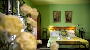 A room with a bed, two paintings on the wall, and a wooden headboard. - Estudio Deluxe 2 Personas (Andújar)