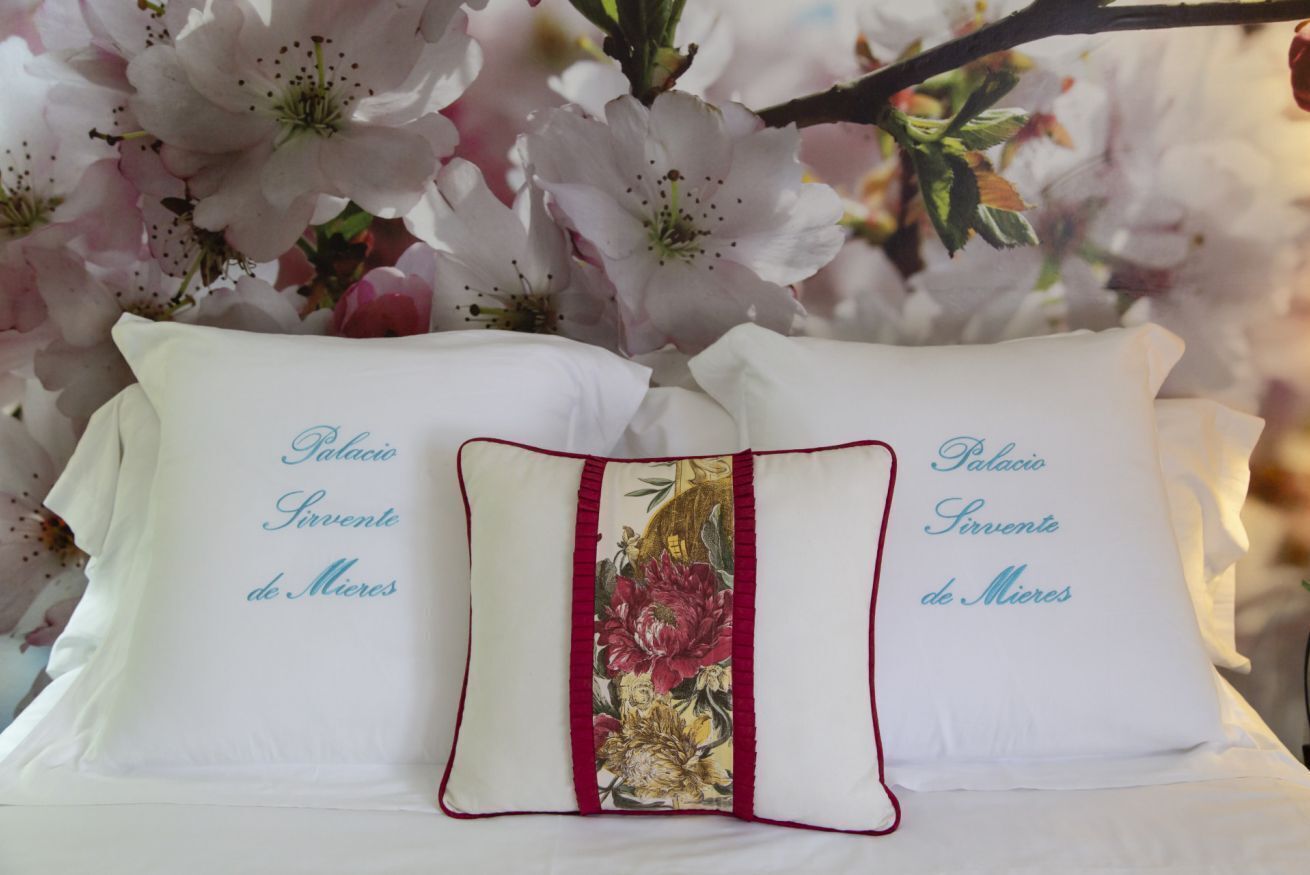 Two pillows with text and a decorative pillow between them.