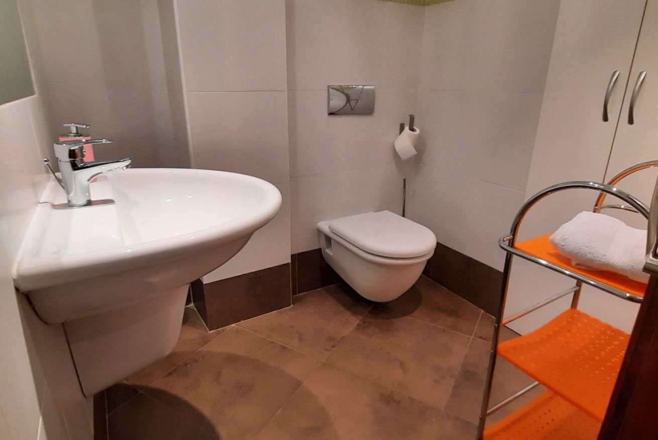 A bathroom with a sink, toilet, and towel rack.