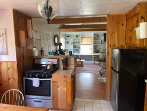 A kitchen with wooden cabinets, a stove, and a refrigerator.