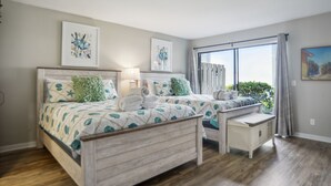Un dormitorio con dos camas, una mesita de noche y una ventana con cortinas.