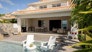 A modern house with a swimming pool, outdoor furniture, and a patio area. - Villa Orlov - Luxury villa on the water (Le Diamant)