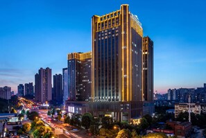 A high-rise hotel with multiple floors, illuminated windows, and a prominent sign at the top. - Wingate by Wyndham Changsha Yuhua (Changsha)