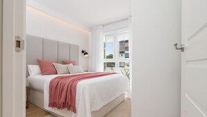 Un dormitorio moderno con una cama grande, una mesita de noche y vistas al exterior.