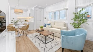 A modern living room with a sofa, a coffee table, and a blue armchair.