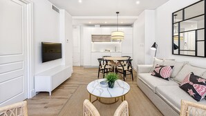 A modern living room with a sofa, a round coffee table, and a dining area with a table and chairs. - iloftmalaga Madre de Dios V - 2B (Málaga)