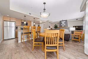 A modern kitchen with wooden chairs, a dining table, and a built-in oven.