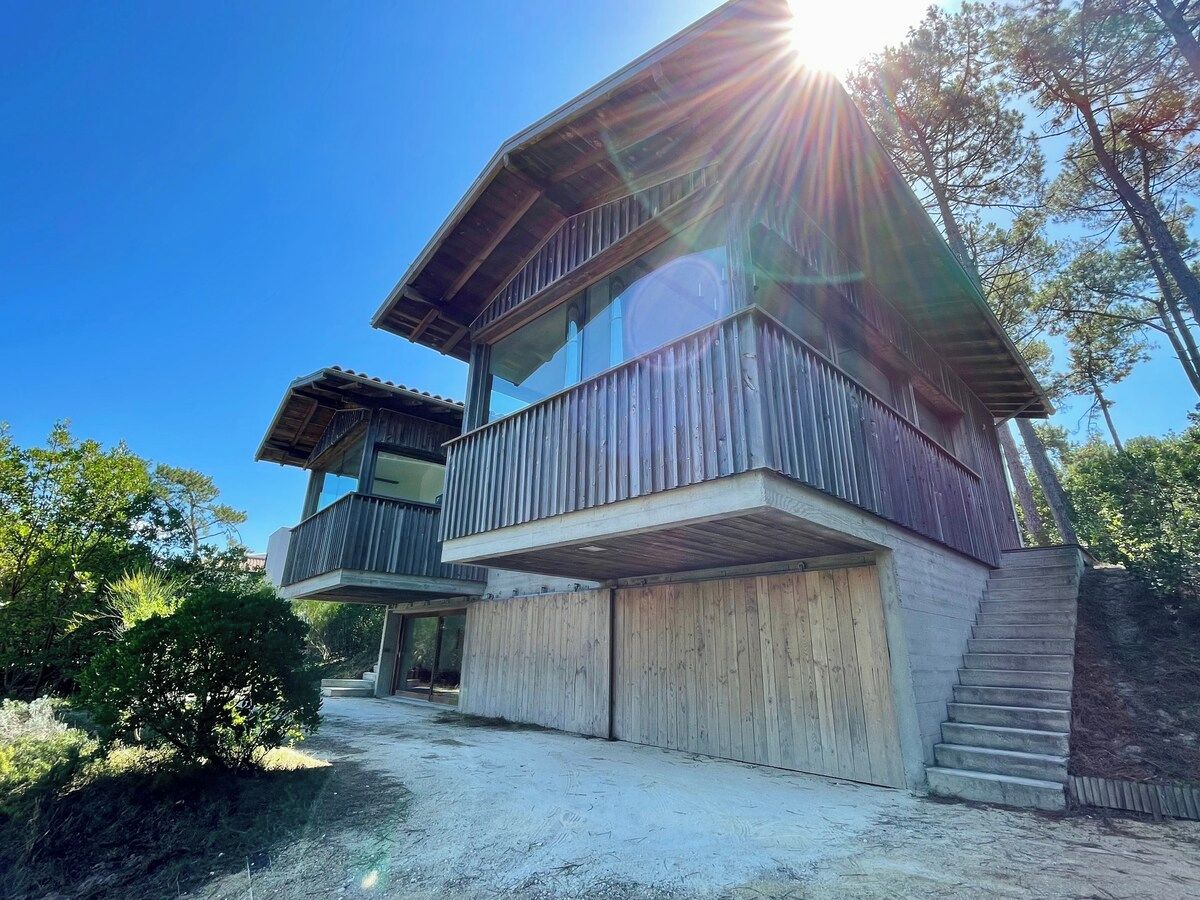 A two-story wooden house with a balcony and a garage.