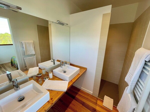 A bathroom with two sinks, a mirror, and a wooden vanity.
