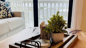 A wooden tray with a potted plant and a decorative item on a table near a window with a view of a balcony. - Boat lovers dream - waterfront unit with dock & walk to the beach (Orange Beach)
