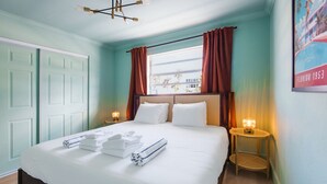 A hotel room with a bed, two bedside tables with lamps, a window with curtains, and a door. - 138 · ☀Pool✔ Kitchen✔ Beach✔ Self Checkin✔ Free Parking✔ (Clearwater)