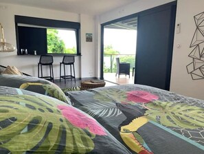 Une chambre moderne avec un grand lit, une télévision et un balcon équipé de chaises.
