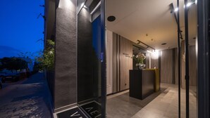 A modern hotel entrance with a reception desk, a sign reading "VELVET," and a well-lit interior. - Velvet rooms & more (Zadar)